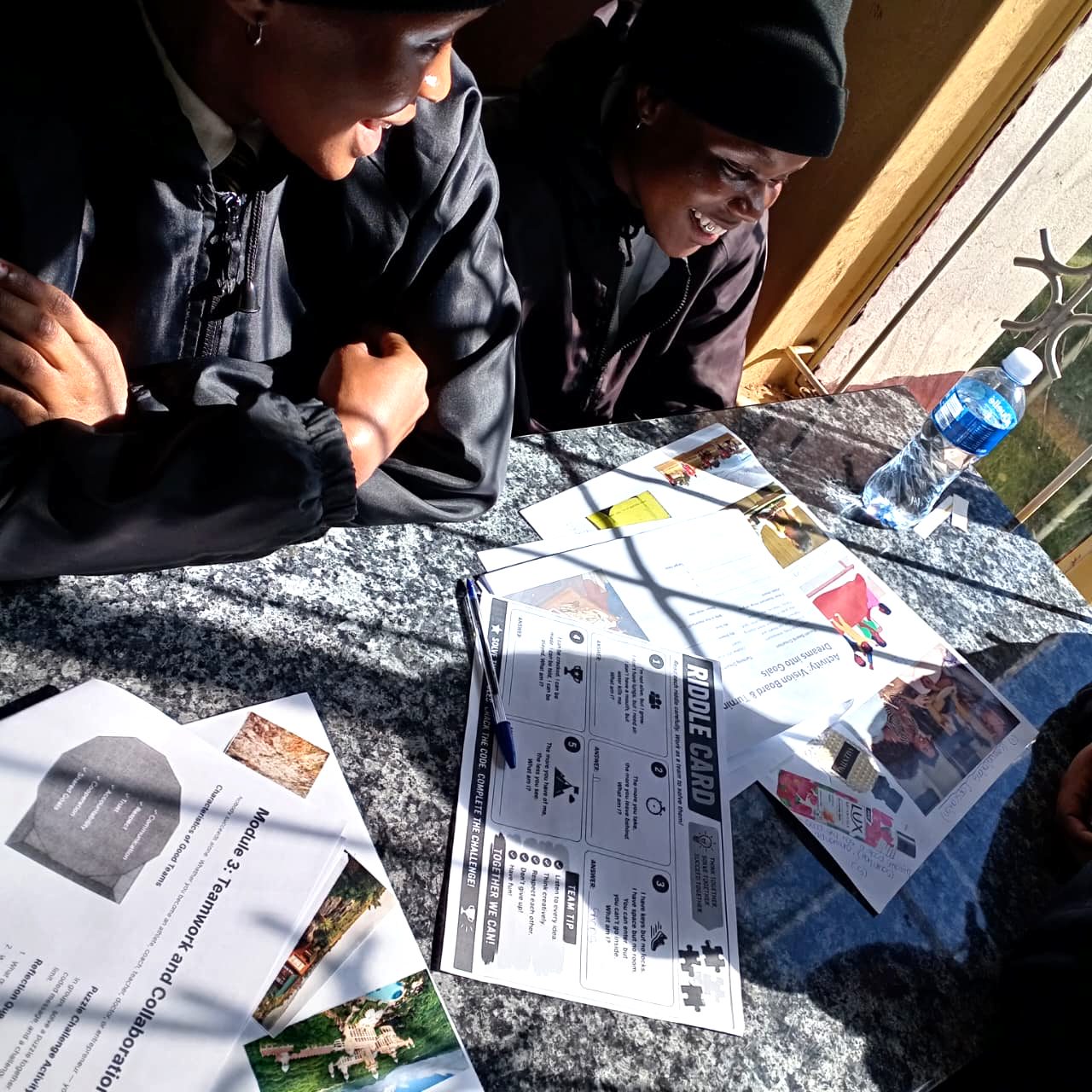 Project Pathway learners solving a teamwork riddle card during a Module 3 session
